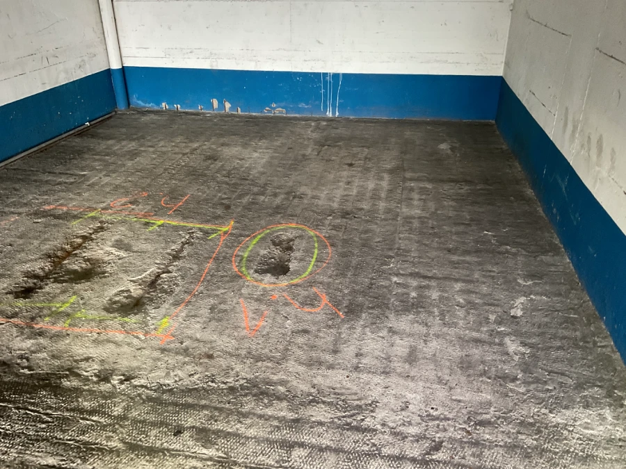 Markierte Schadstellen am Betonboden einer Tiefgarage zur Vorbereitung der Instandsetzung