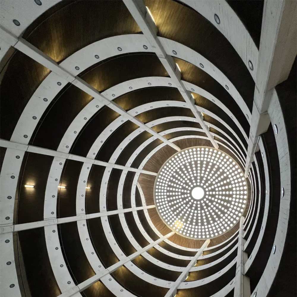 Lichtdurchflutete spiralförmige Parkhausarchitektur aus Beton