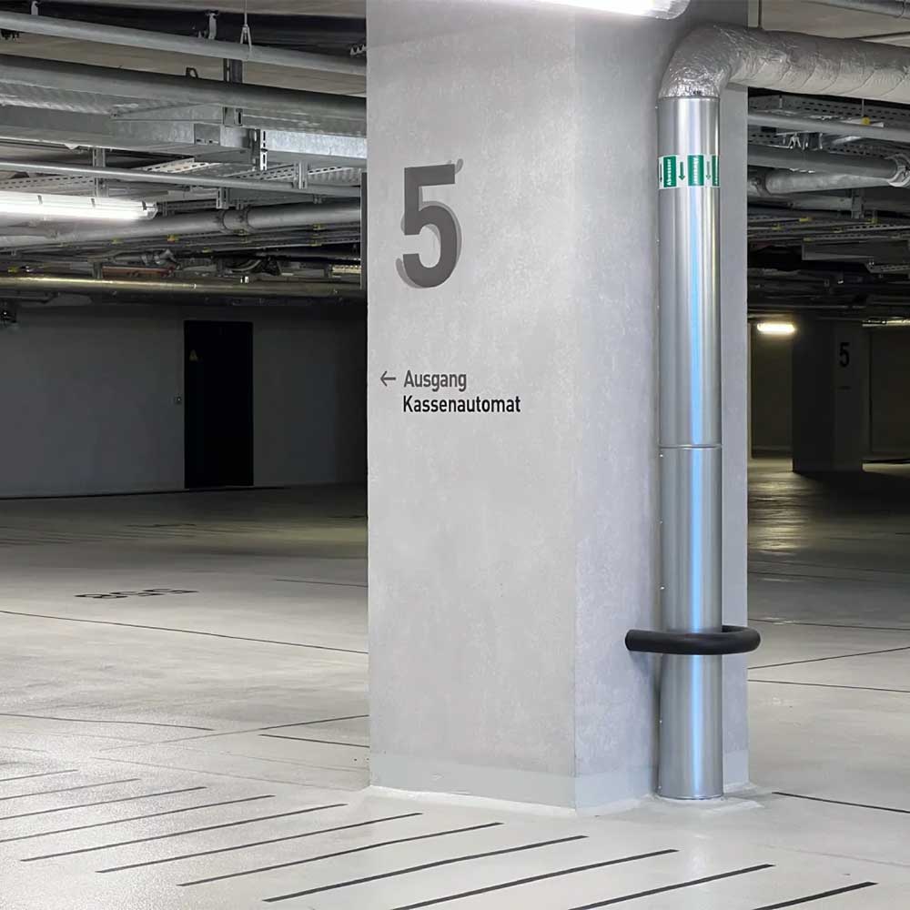 Betonstütze und Rohrsystem im Parkhaus während der Bauwerksinspektion