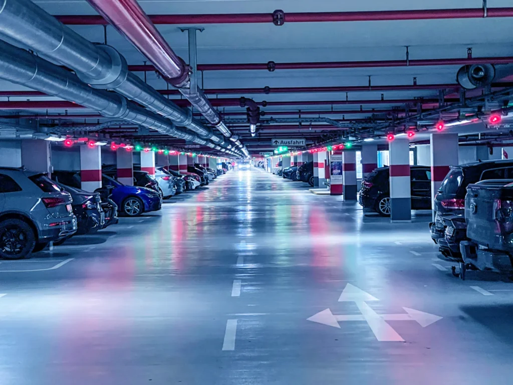 Beleuchtete Tiefgarage nach abgeschlossener Instandsetzung mit sanierten Flächen und Markierungen