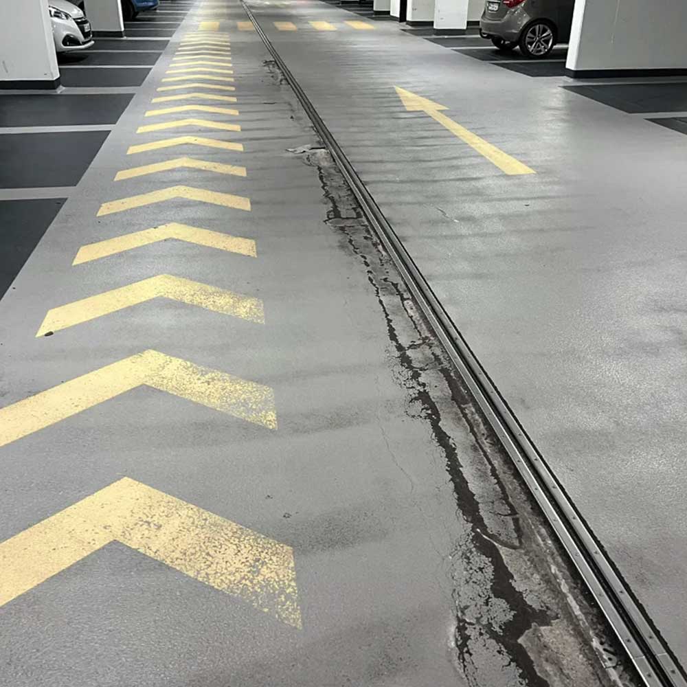 Risse und Schäden im Boden einer Tiefgarage vor der Inspektion
